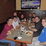 Photo of trombone students around a table at dinner during Winter 2011.